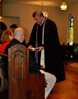 Dr. Dan serving communion to elders